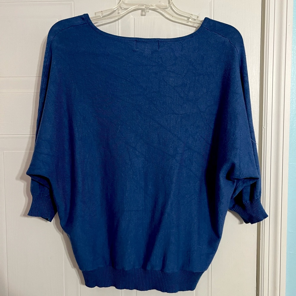 A loose fitting, blue, short sleeved sweater